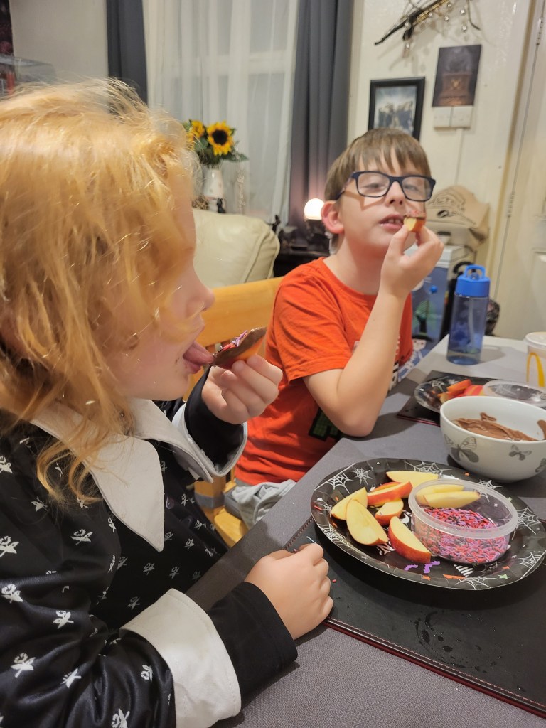 pandora & warren enjoying apple slice dipped in chocolate